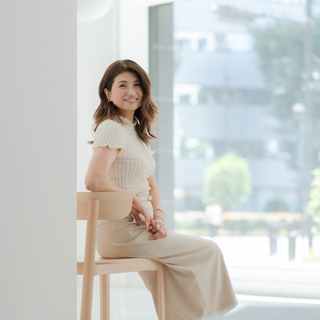 Portrait of a Satomi Yoshida-Katz, Founder and Principal of YZDA, seated in a bright neutral interior for the Edgewater condo project