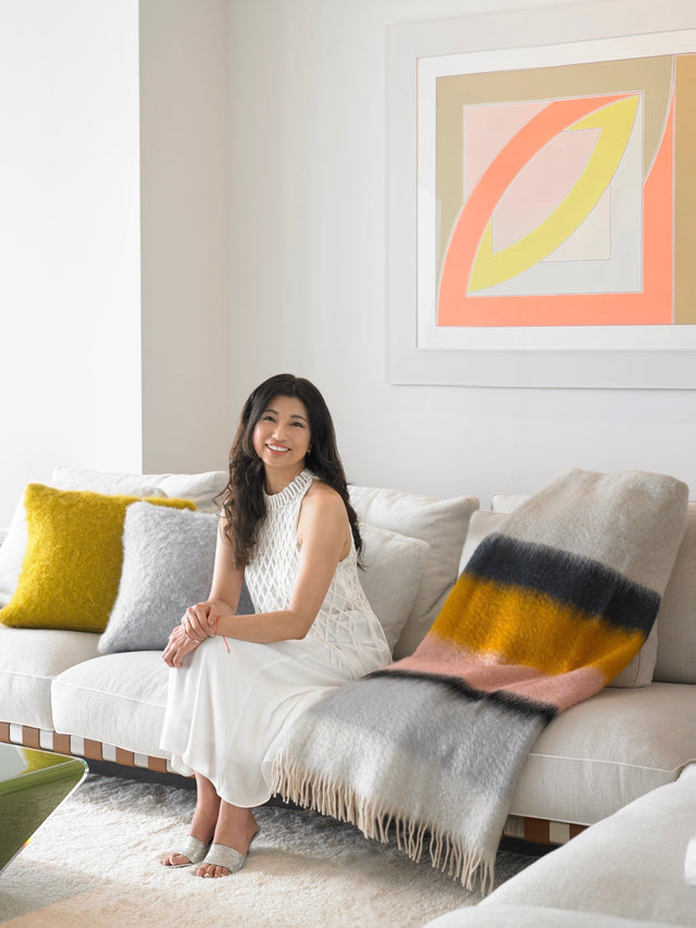 Satomi Yoshida-Katz, founder of YZ Design Atrium, seated in the Armani Casa Miami condominium she designed, featuring neutral furnishings and modern art.