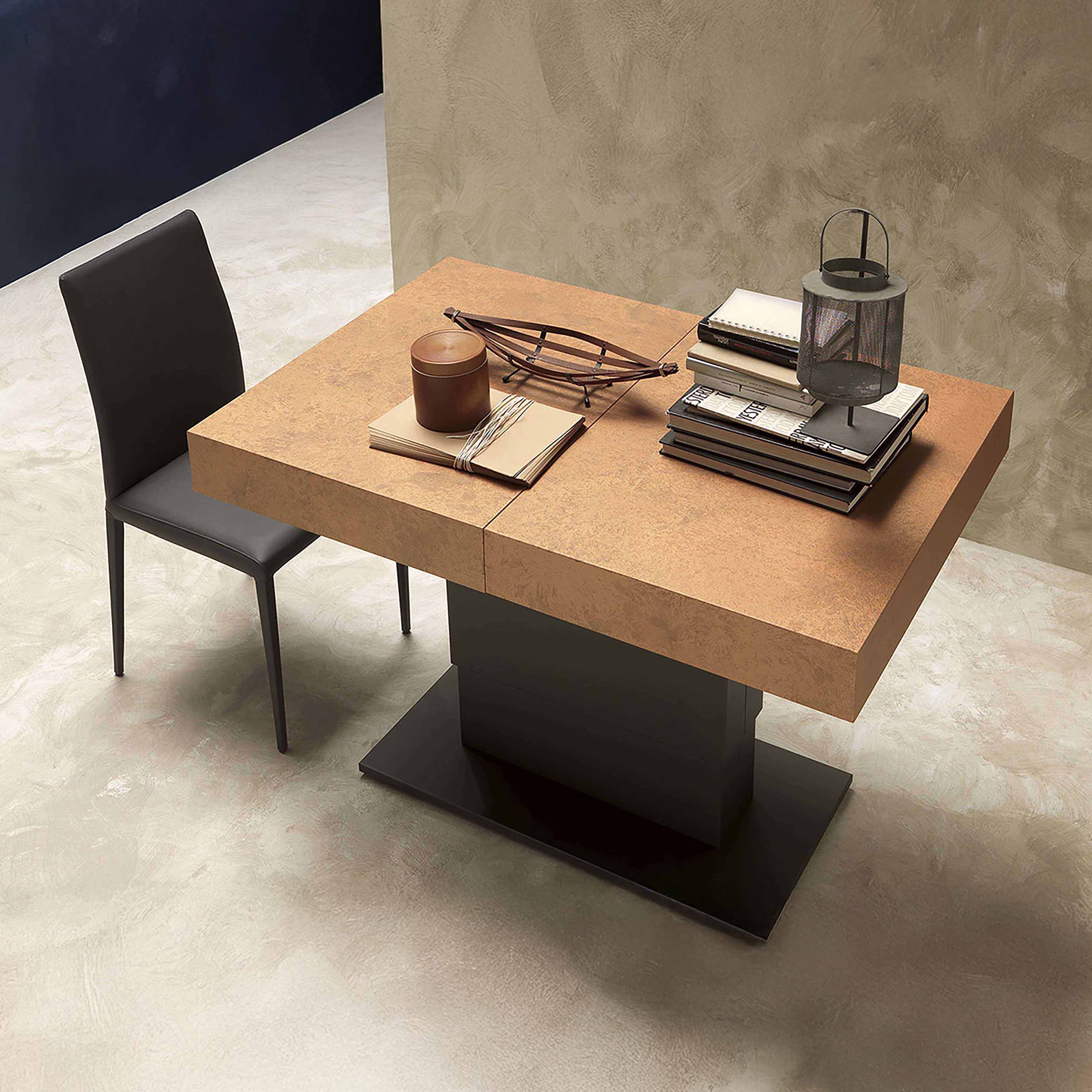 The Ceres table in a rust-toned ceramic finish, shown in a modern space with minimalist furniture and textured walls.