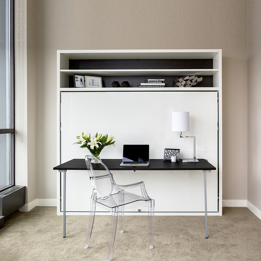 Adam Tavolo Queen Murphy bed with desk and overhead shelving shown closed in a naturally lit modern room, featuring a laptop and flowers arranged on the integrated workspace.