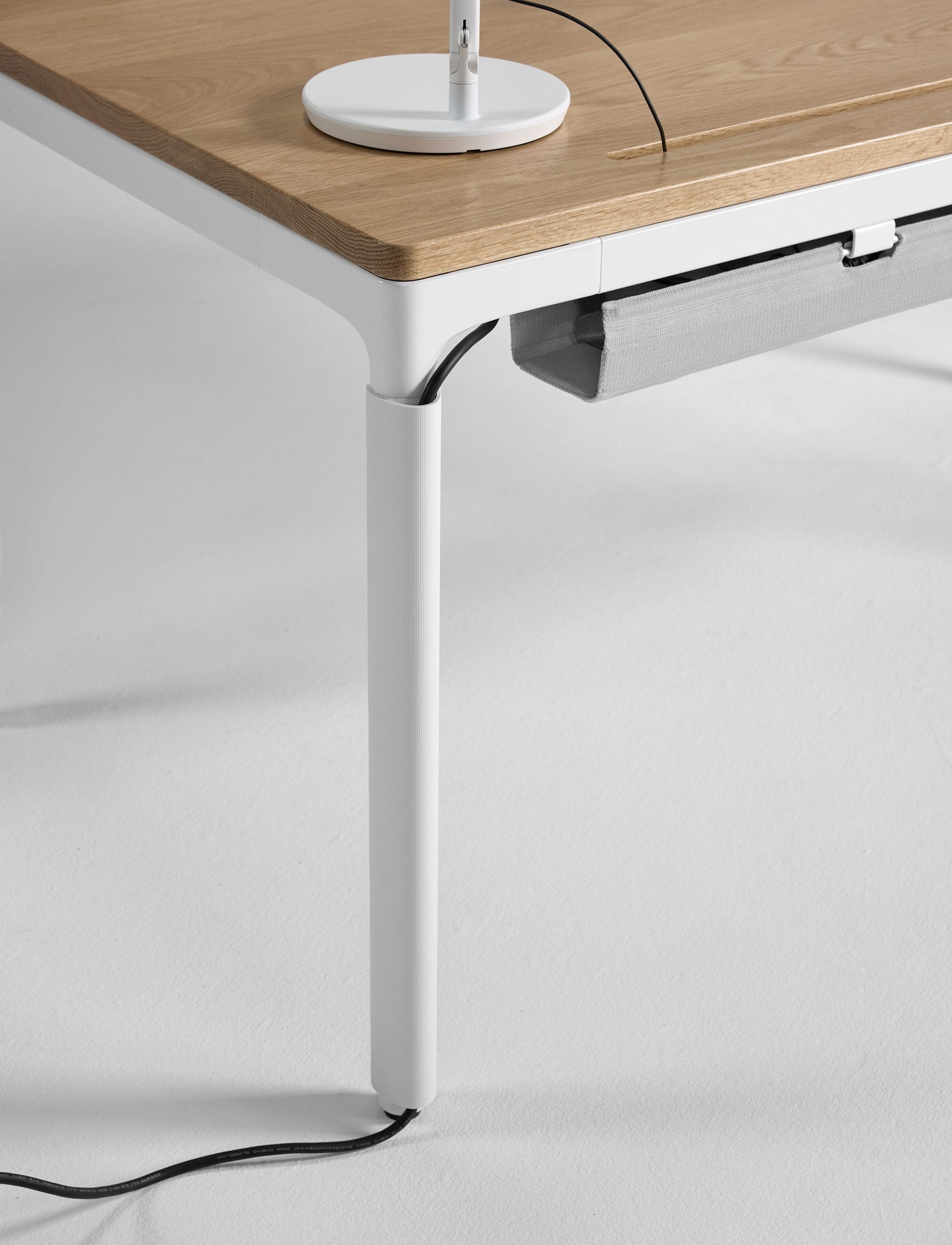 Side view of the eFloat Quattro standing desk with white sculpted legs and solid wood top.