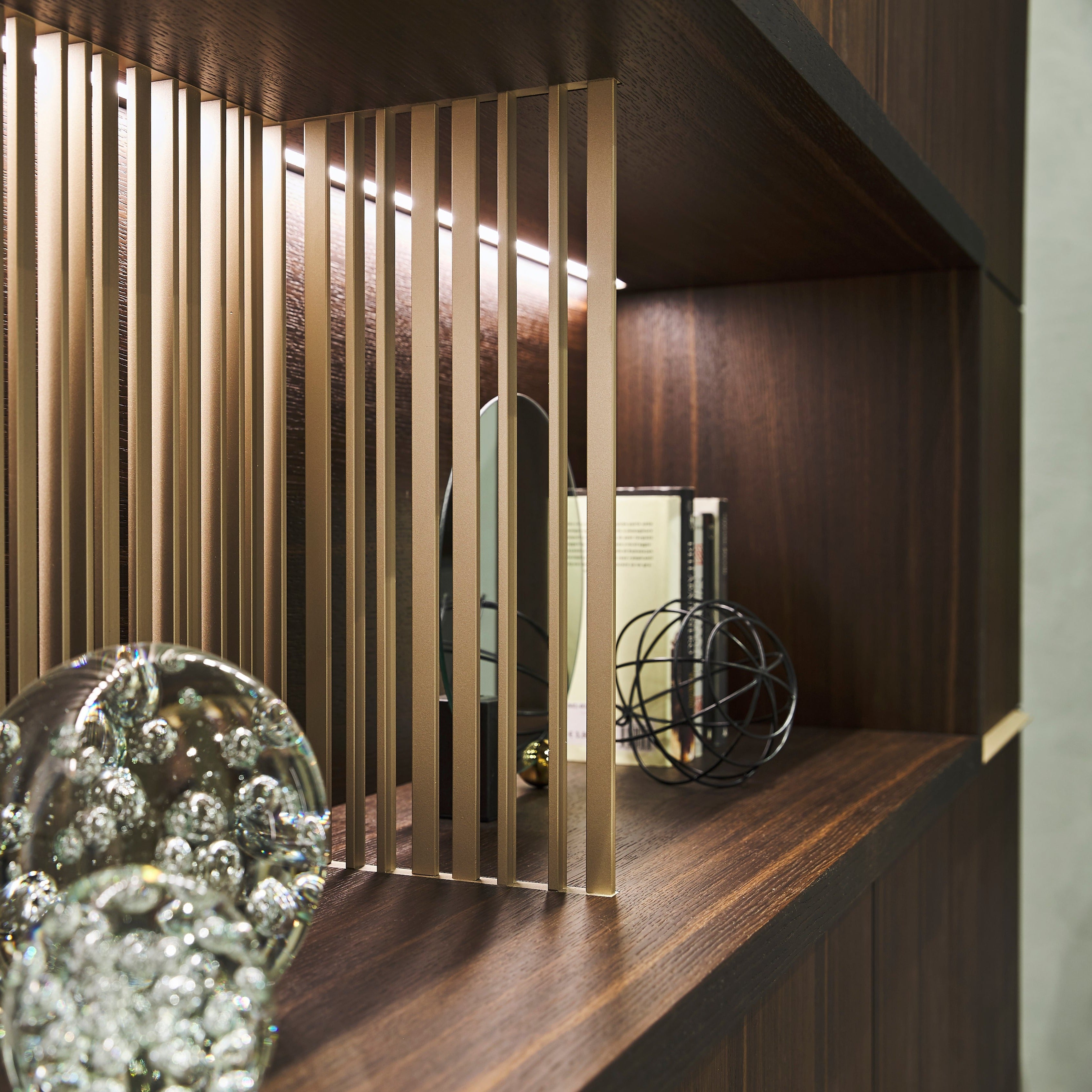 Close-up of decorative divider detail with LED-lit shelving in custom entryway cabinet – space saving furniture by Resource Furniture.