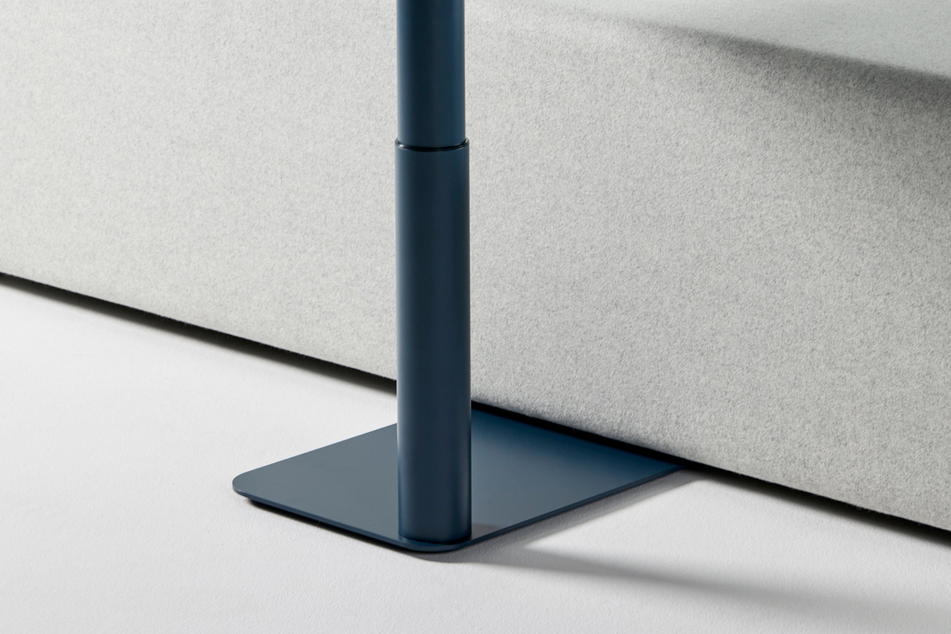 Detailed close-up of the Float Micro’s steel blue base and post design with textured matte finish.