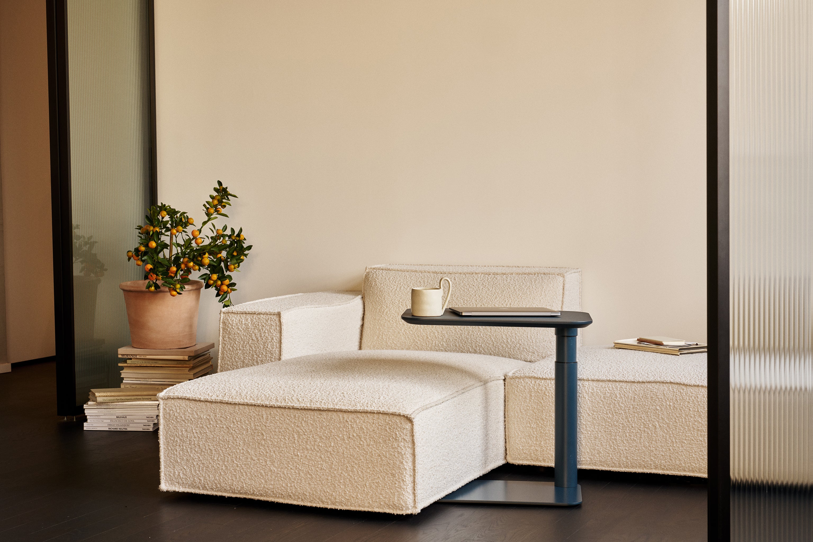 Lifestyle view of Float Micro with white base in a clean, plant-accented interior under natural daylight.