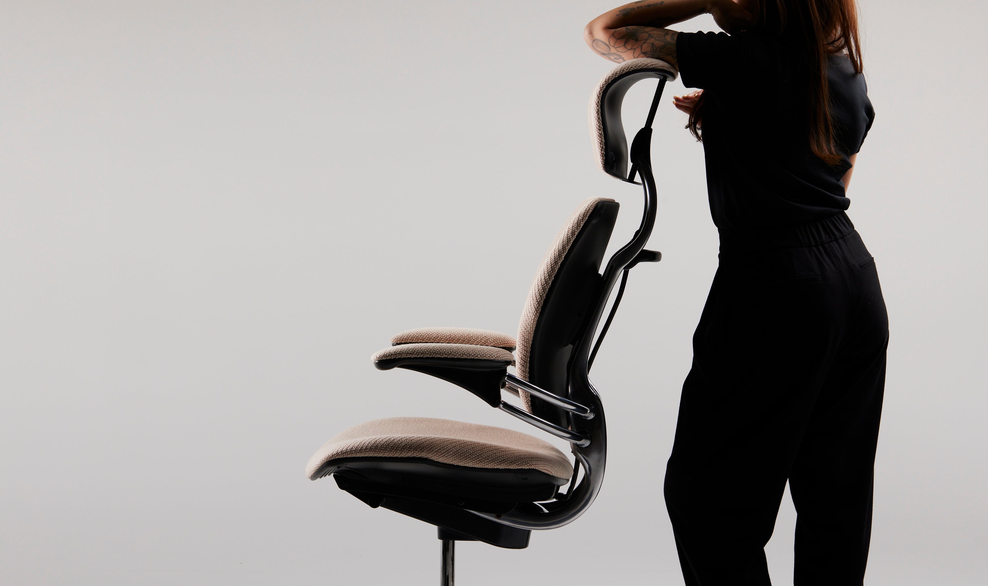 User leaning on the Freedom Headrest office chair, highlighting sculptural back and integrated headrest design.