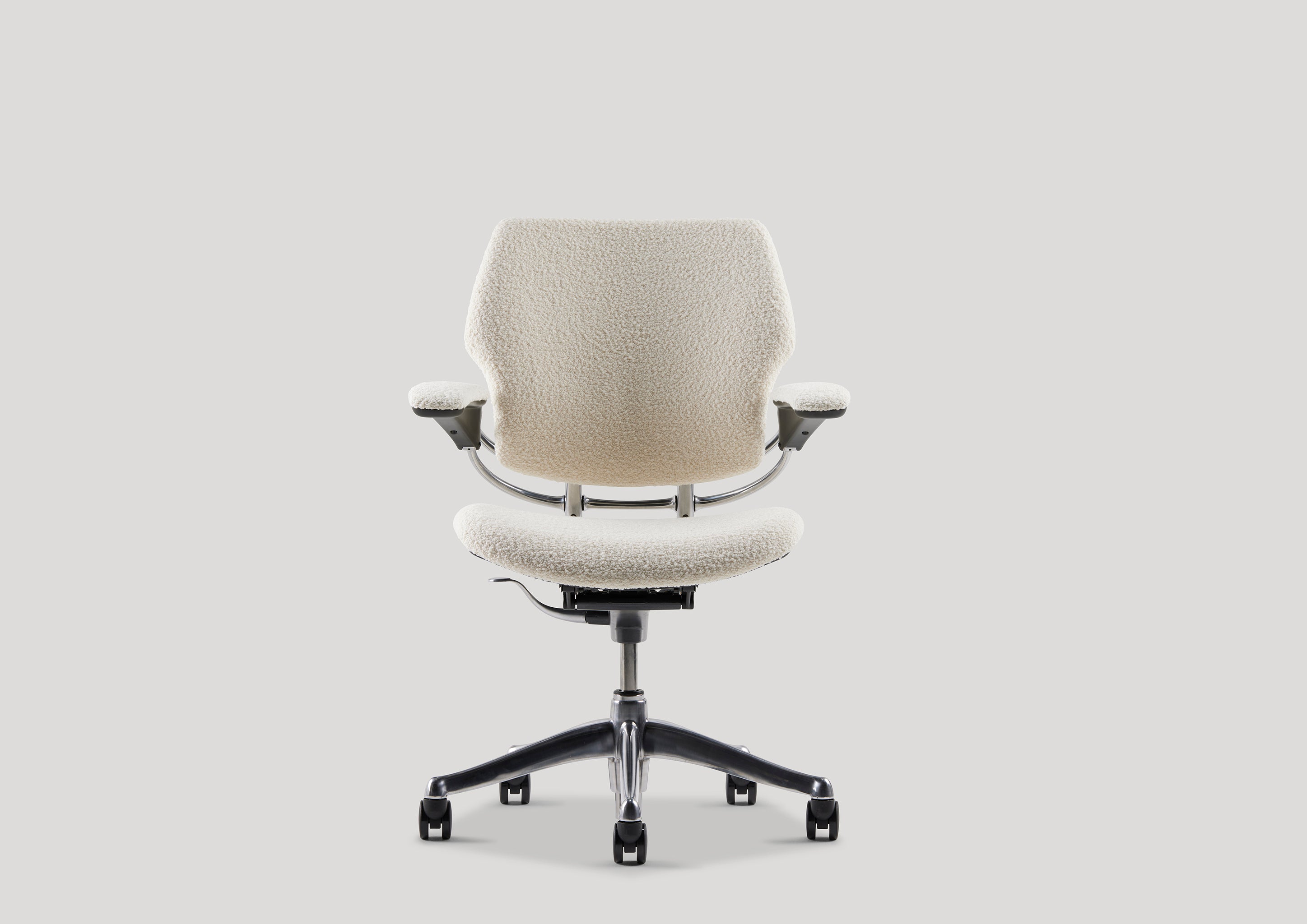 Studio front view of Freedom Task Chair in ivory bouclé upholstery, highlighting its minimalist form and supportive contouring.