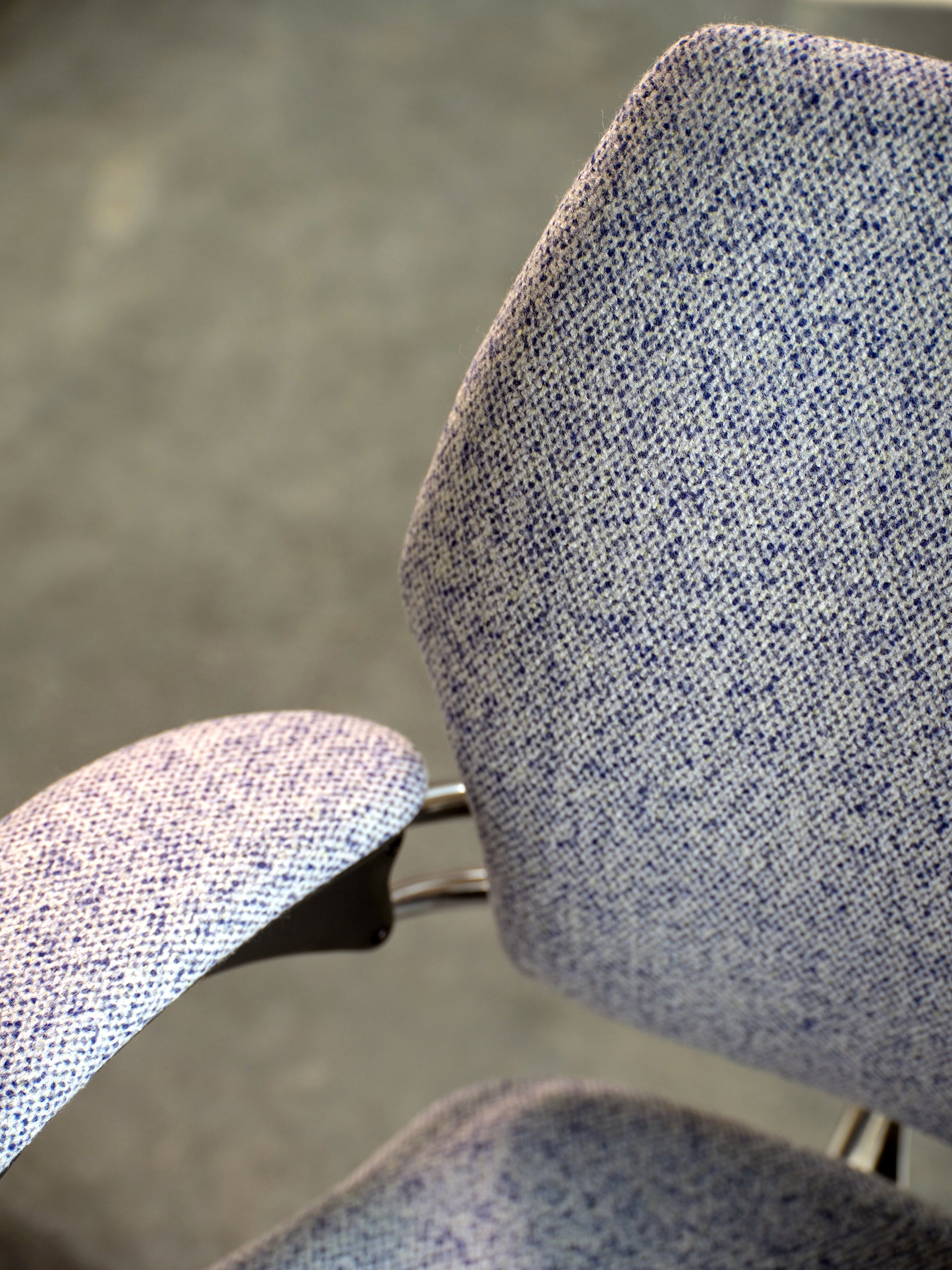 Close-up of Freedom Task Chair with lavender-blue textured upholstery, showcasing armrest and back support curvature.