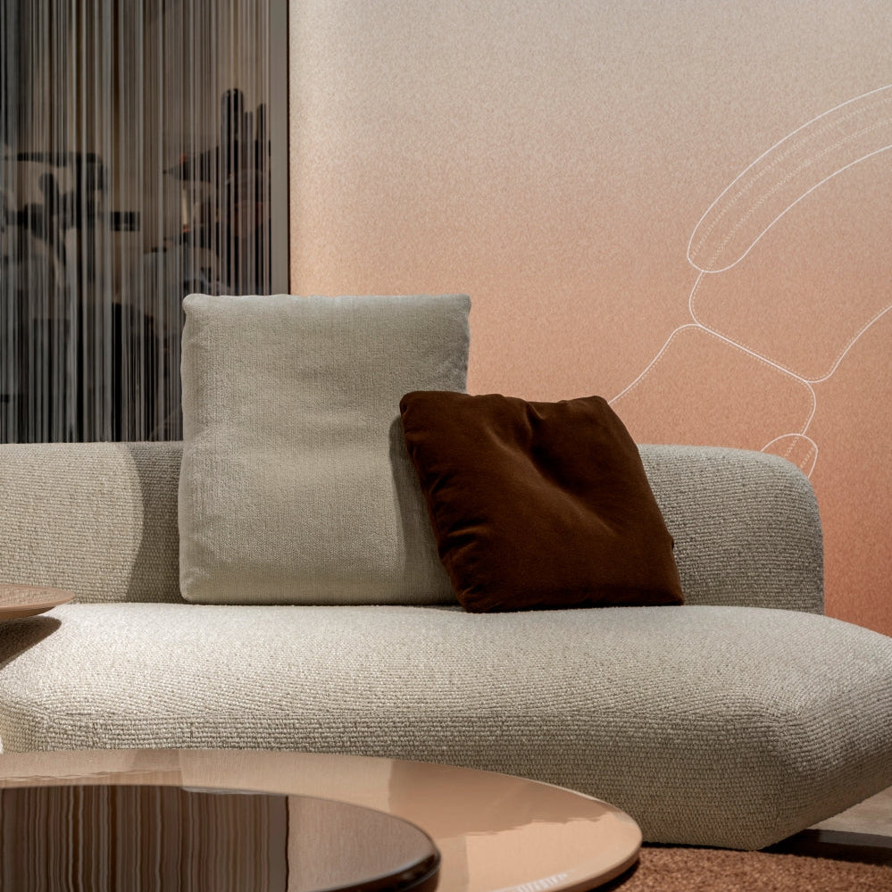 Kintai modern sectional sofa with cream upholstery and brown accent pillow.