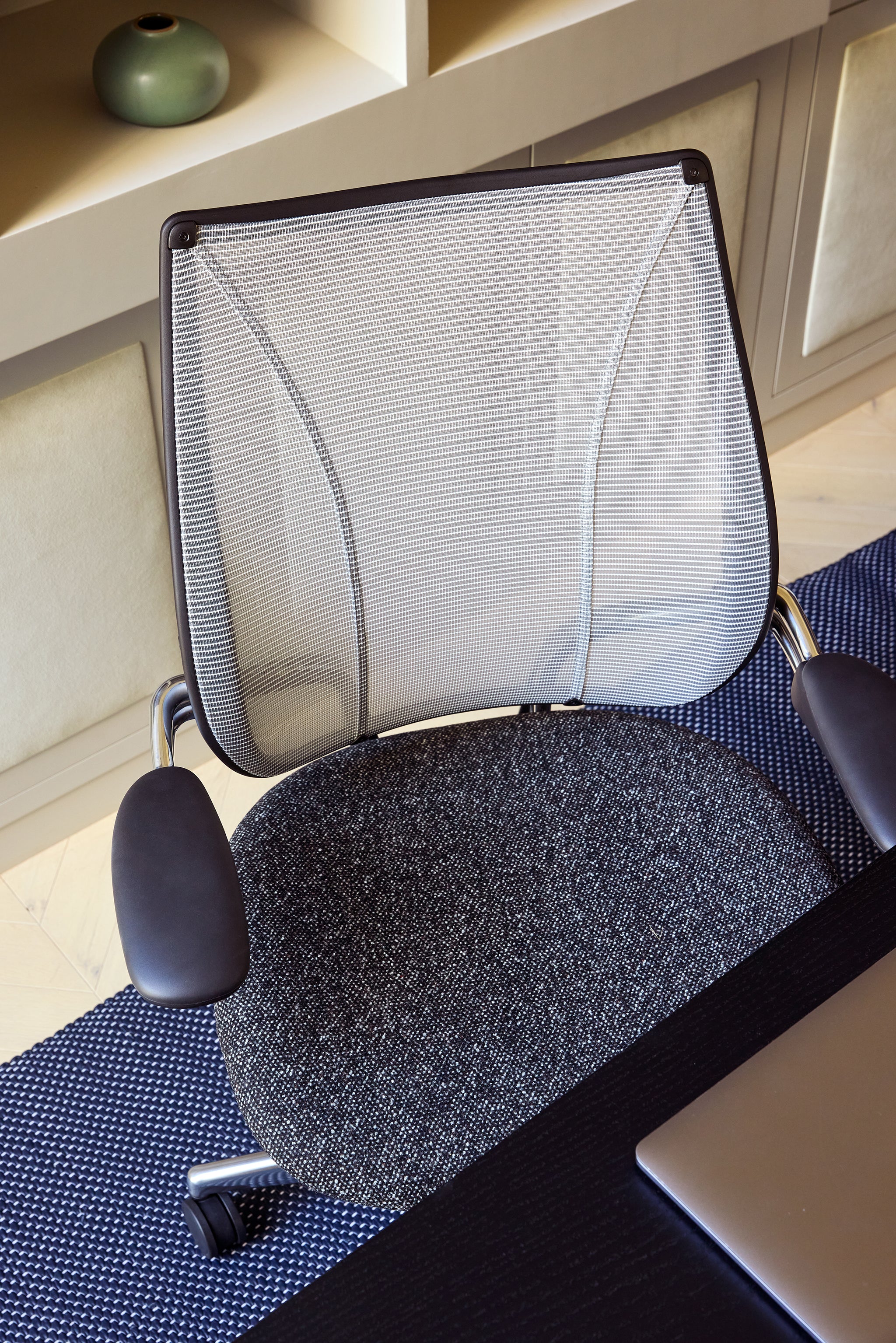 Detail view of Liberty Task Chair highlighting the mesh backrest and textured charcoal seat fabric in a contemporary workspace.