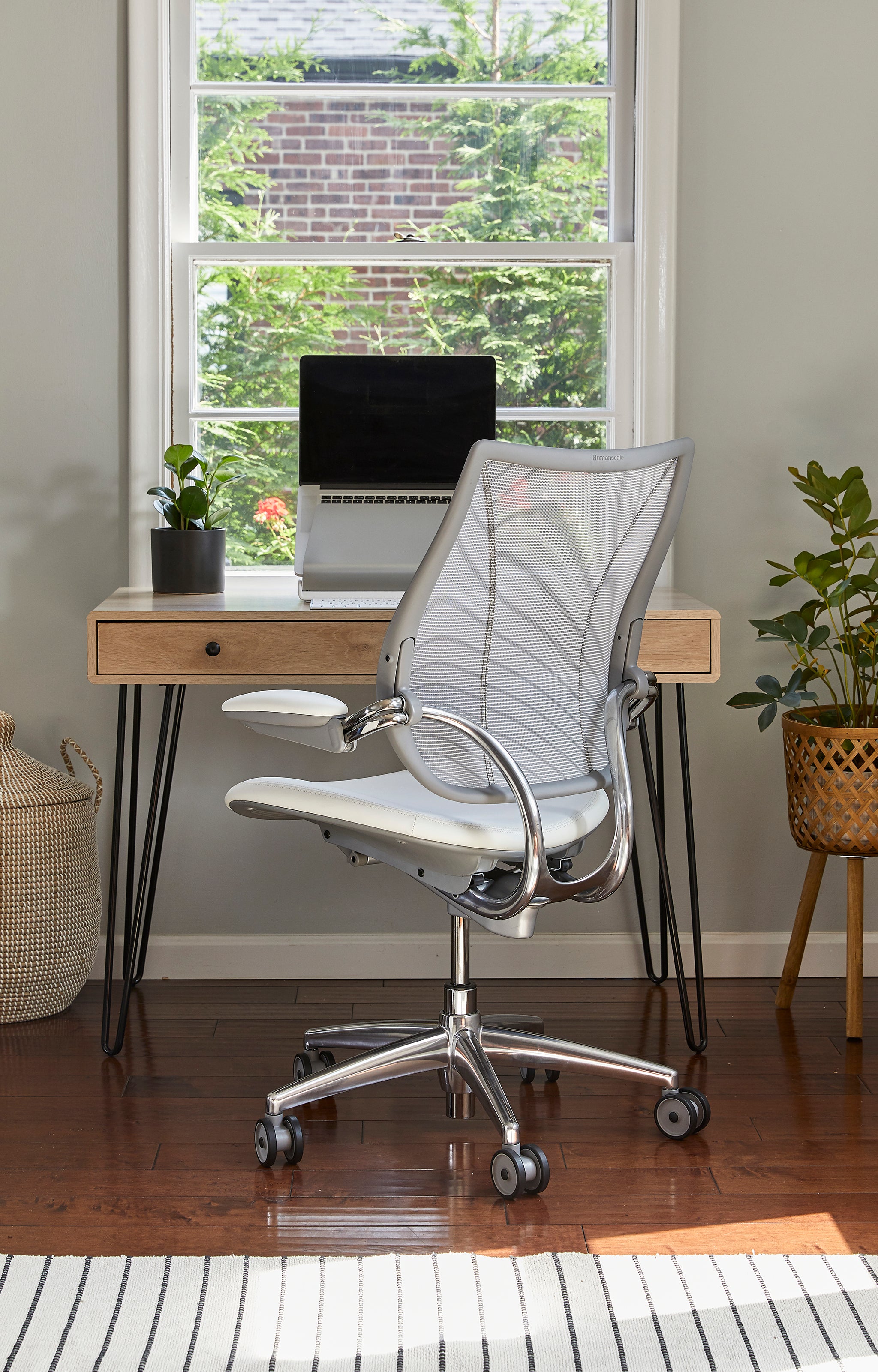 Liberty Task Chair in white mesh shown in a bright home office with a wood desk and laptop.