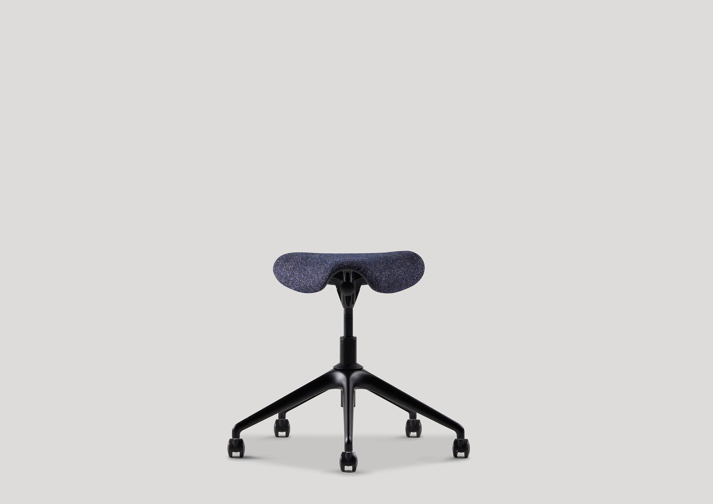 Rear view of the Pony ergonomic saddle stool in navy Kvadrat fabric with contoured seat and caster base.