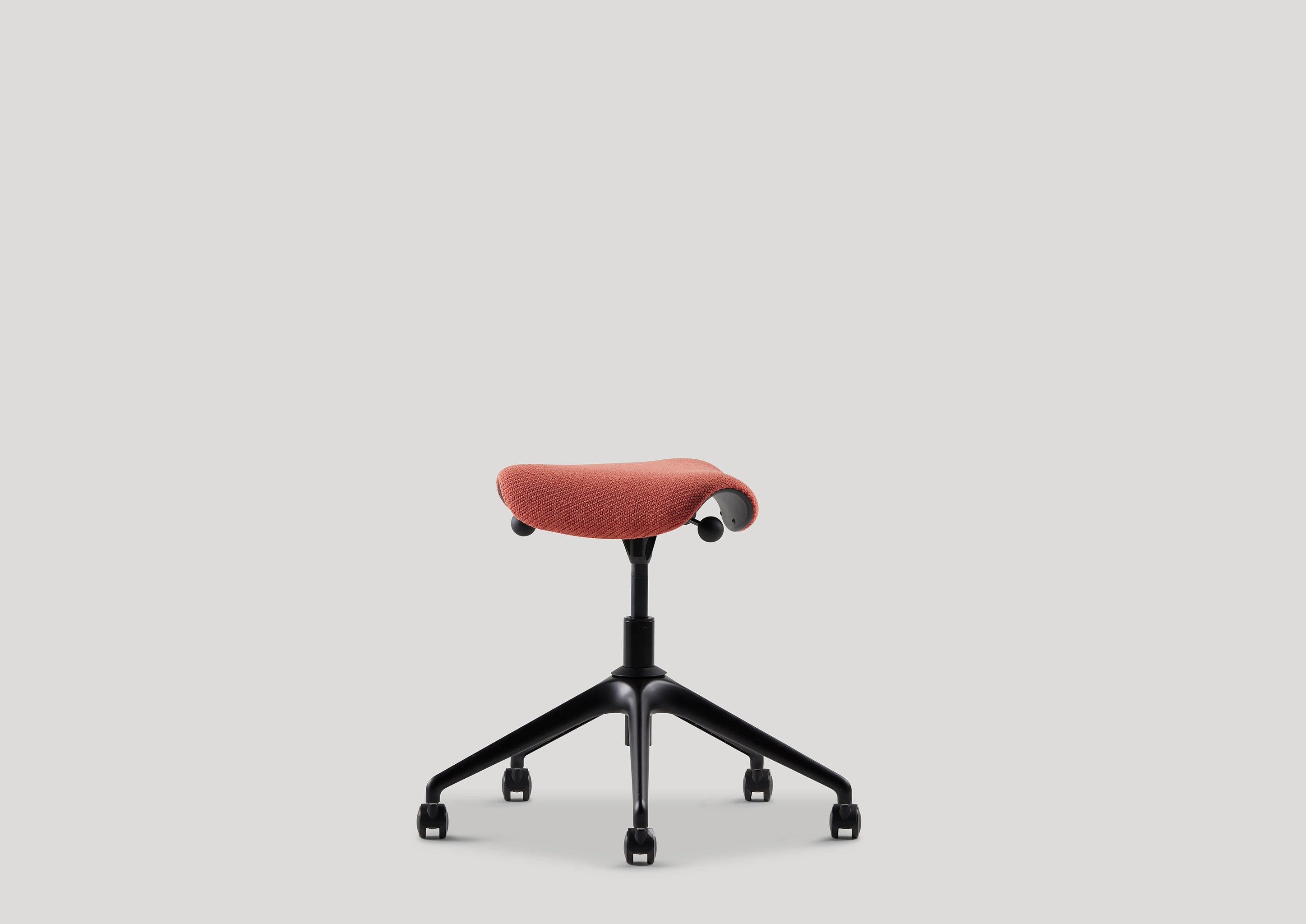 Side profile of Pony stool with rust Kvadrat fabric, designed for ergonomic support and flexible task seating.