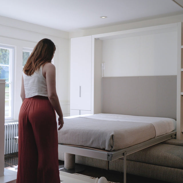 Woman demonstrating the transformation of the Tango Sofa wall bed system in a compact, modern space—ideal for multifunctional small-space living.