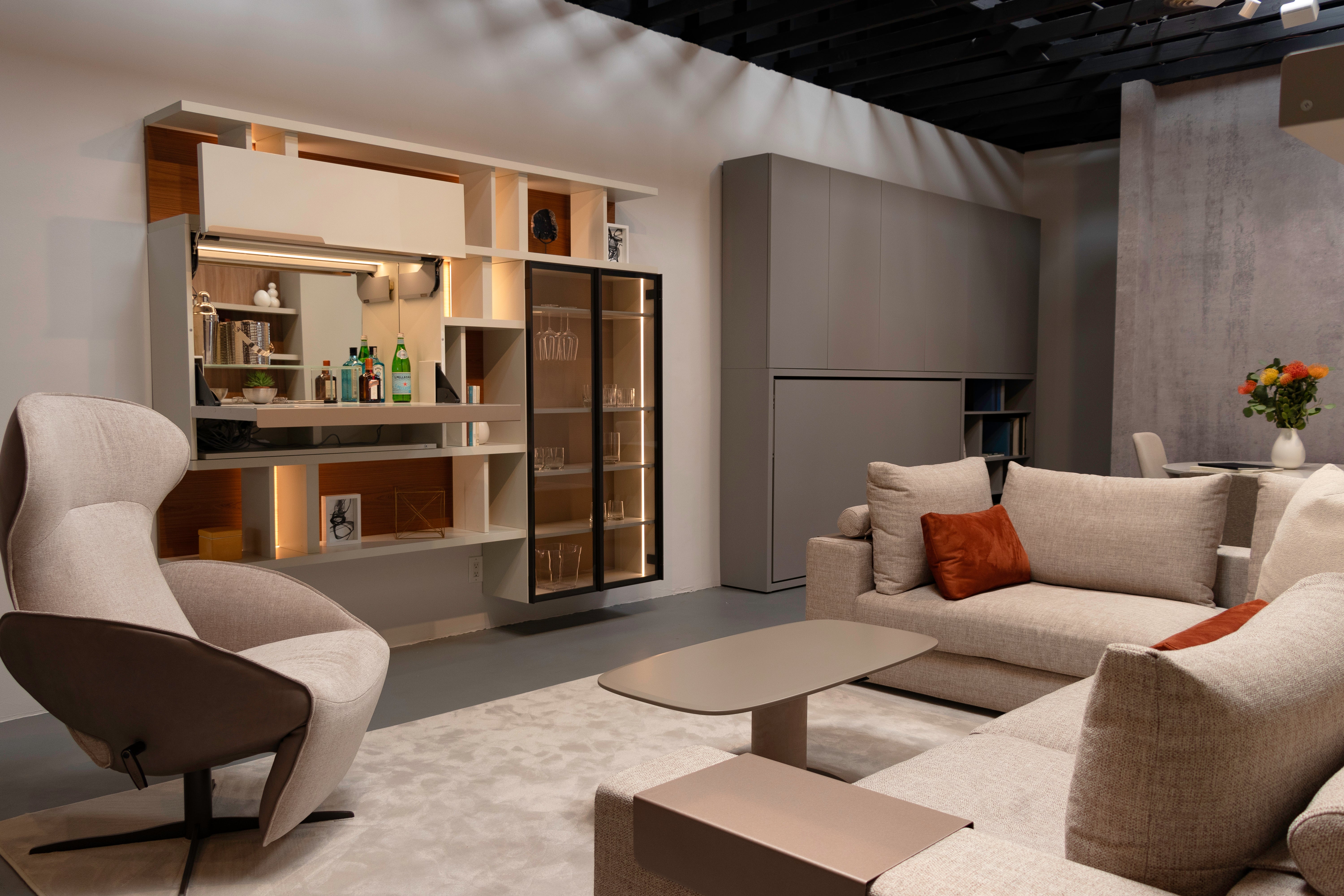 Maxi Bar open in a modern living room with integrated shelving, illuminated glass cabinet, and lounge seating.