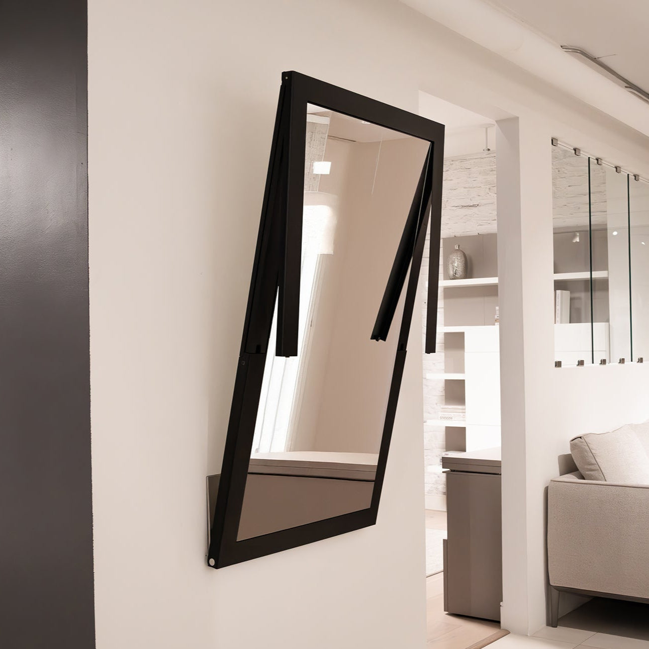 Specchio mirror partially unfolded, transitioning into a wall-mounted table.