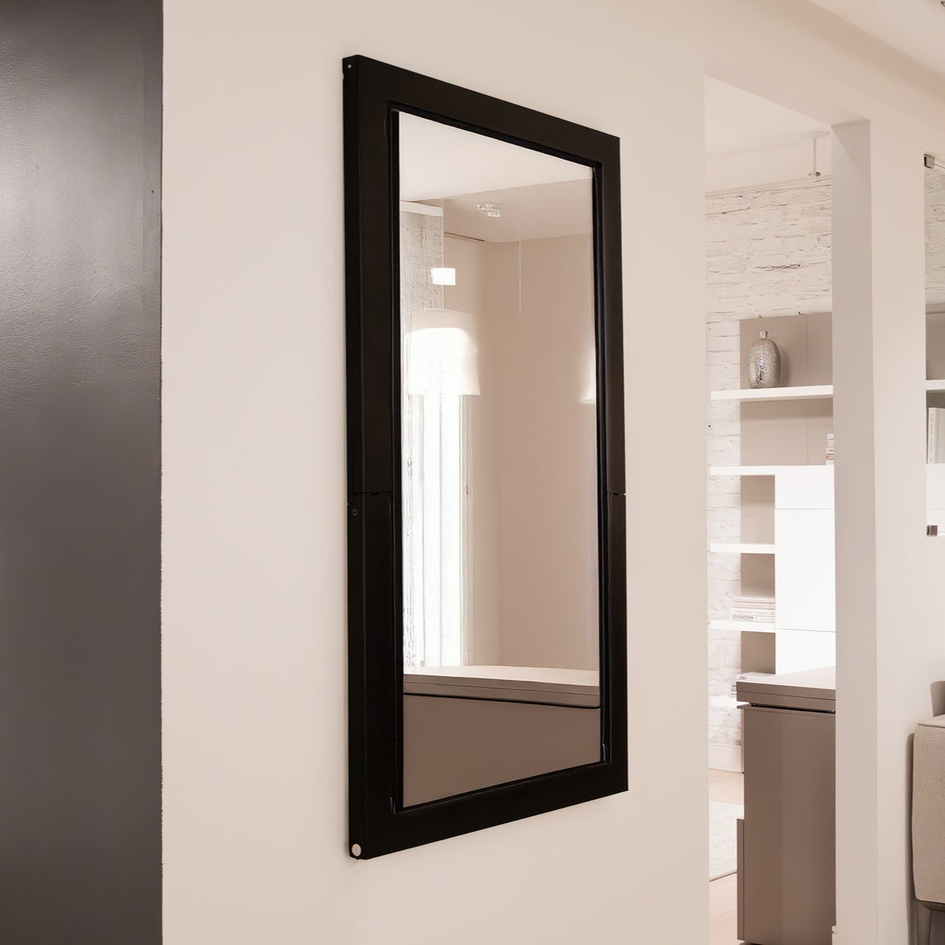 Wall-mounted Specchio mirror in closed position, flush against the wall.