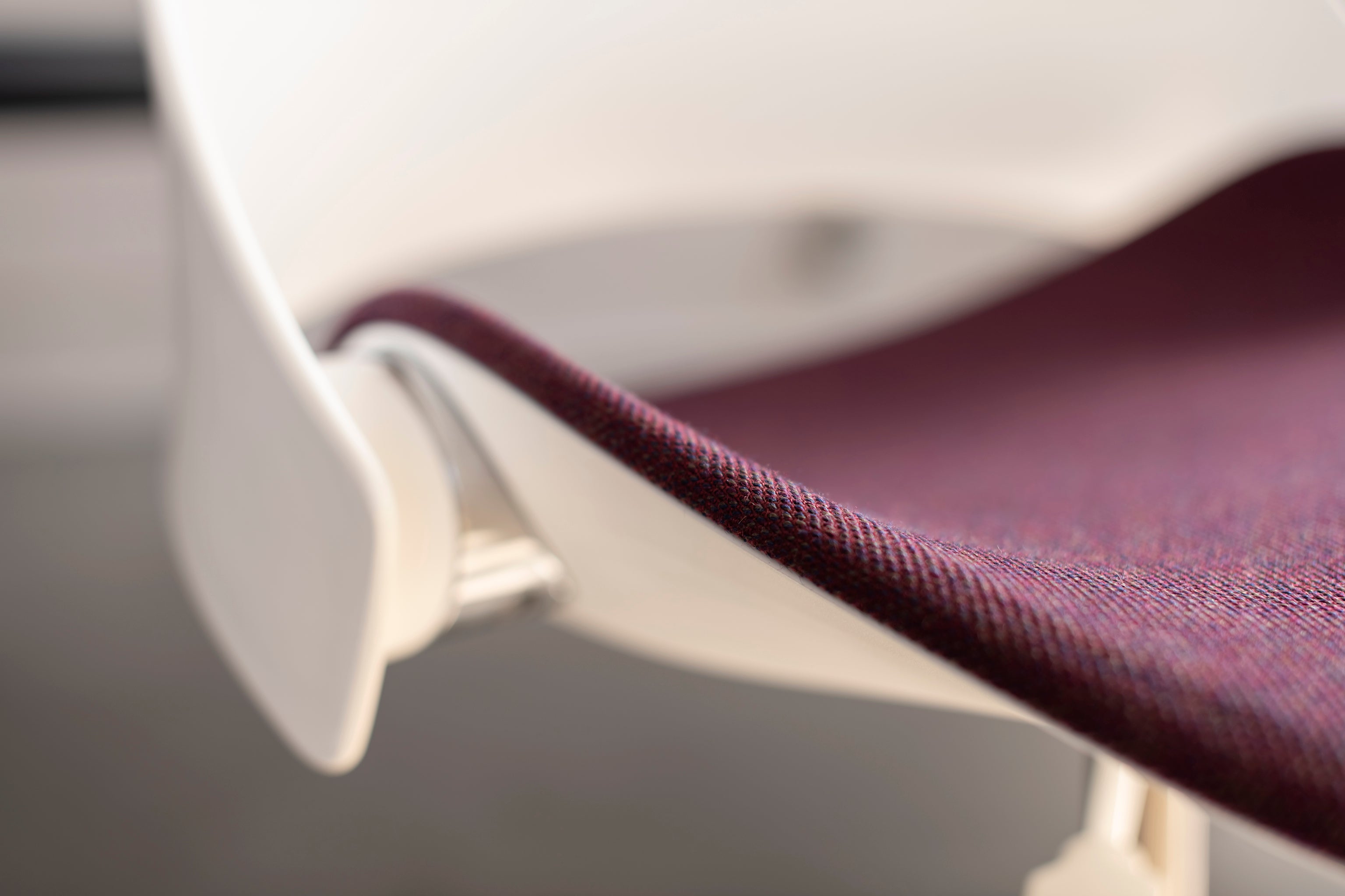 Detail of the Trea Chair’s purple upholstered seat, highlighting premium textile and subtle curvature.
