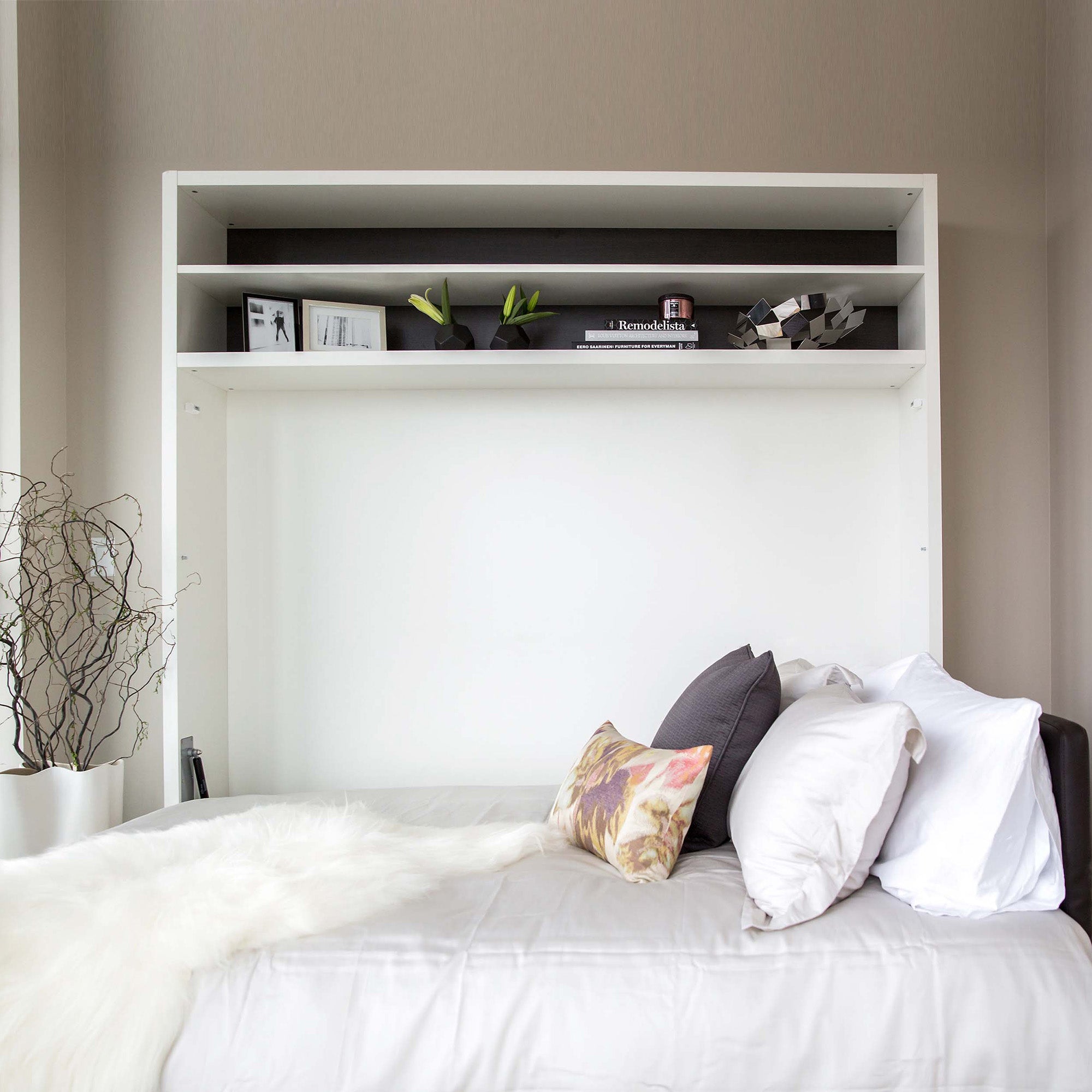Adam Tavolo Queen horizontal Murphy bed shown open and made with layered bedding and multiple pillows — a stylish, space saving furniture solution with overhead shelving.