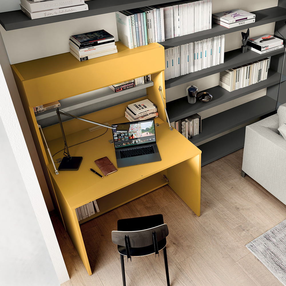 Overhead view of yellow Home Office desk setup with open laptop and shelving, adjacent to the Tonale sectional murphy bed in a modern multifunctional living space.