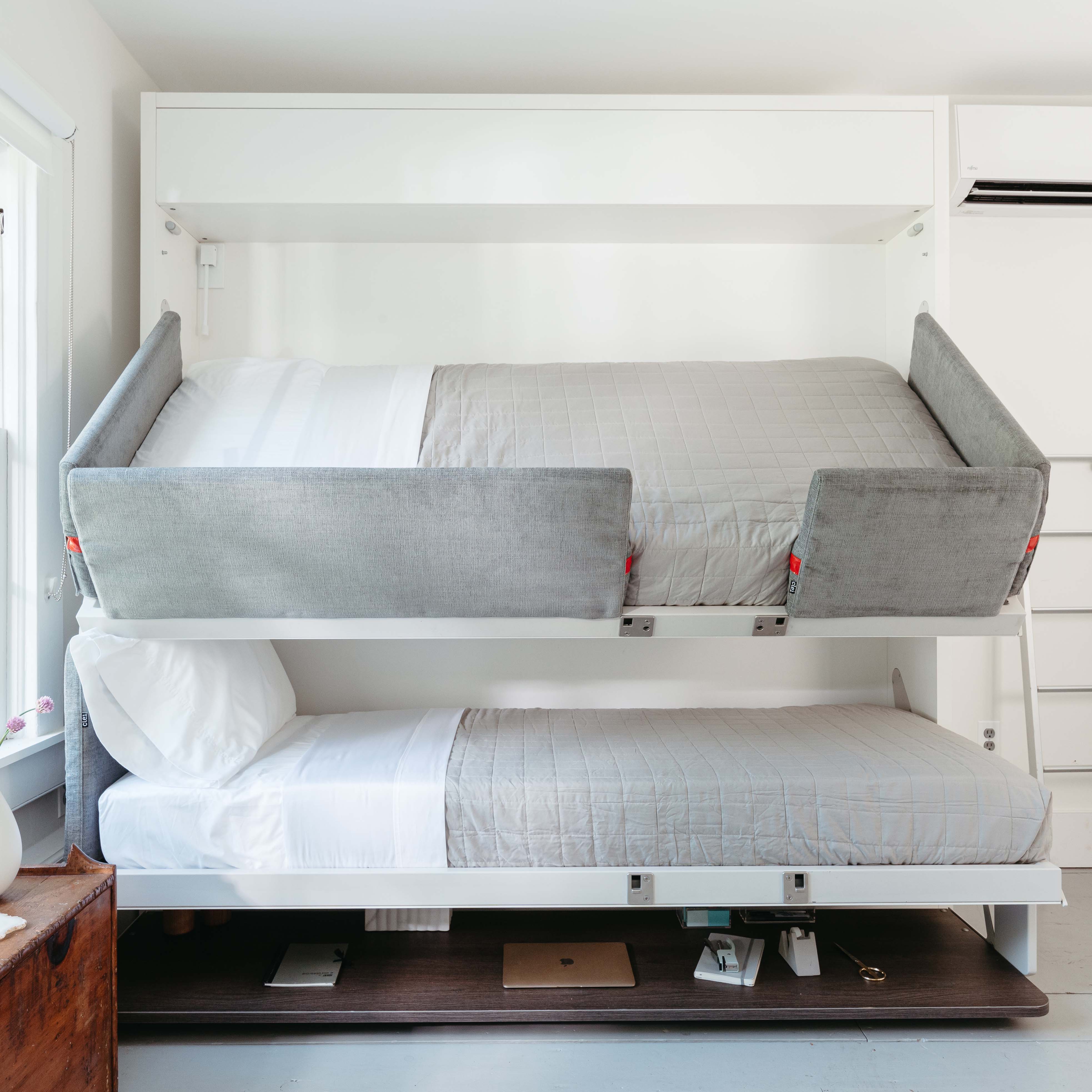 Kali Duo Desk Murphy bunk beds with the top bunk tilted downward, showing easy access for changing bed sheets and upholstered side panels