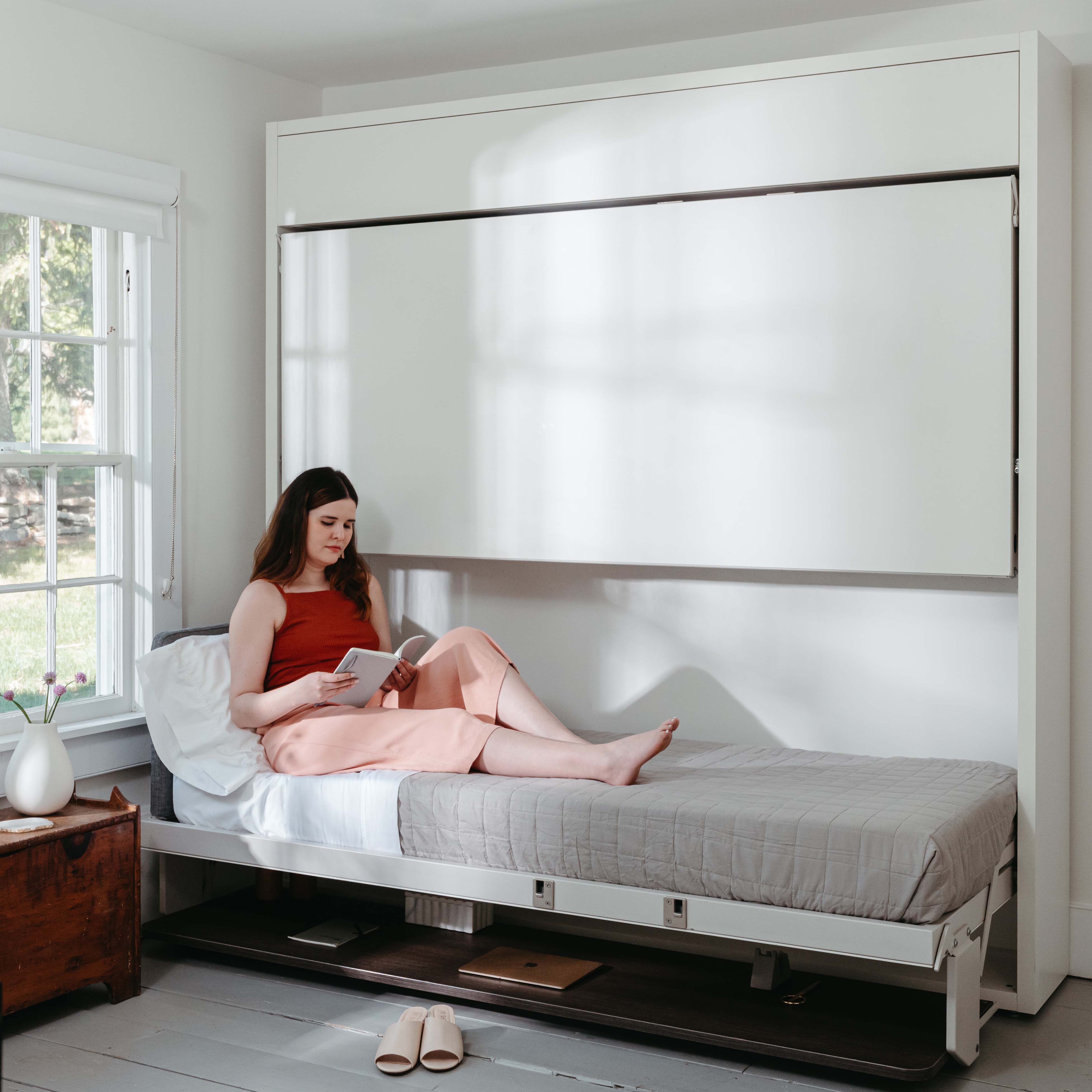 Woman relaxing on the Kali Duo Desk XL Twin Murphy bunk bed, a multifunctional space saving furniture solution with integrated desk.
