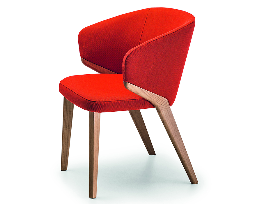 Studio view of Nora dining chair with red upholstered seat and wraparound backrest, featuring angled solid walnut legs.
