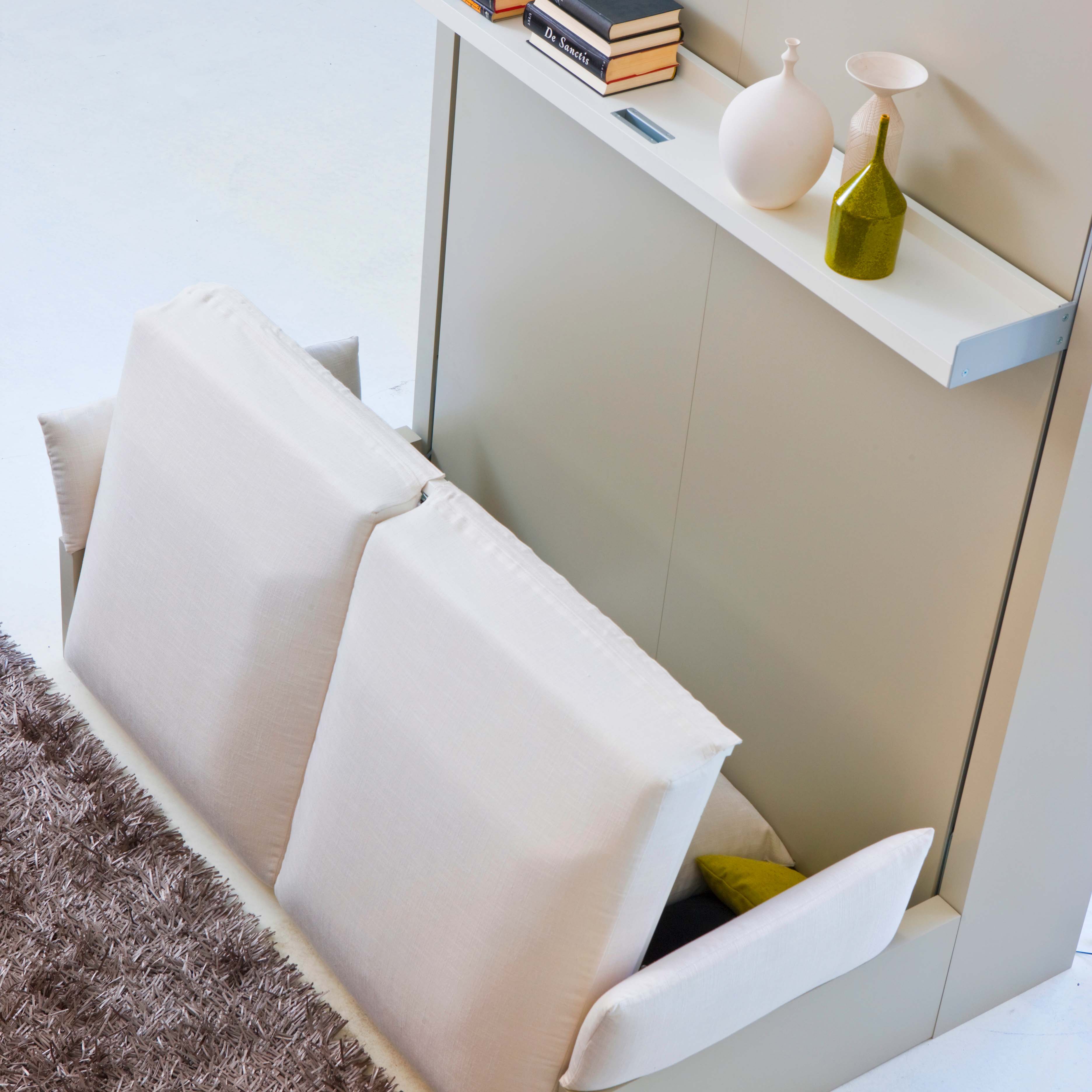 Close-up of Nuovoliola wall bed in the middle of its transformation from a sofa, showing the concealed mechanism and integrated floating shelf.