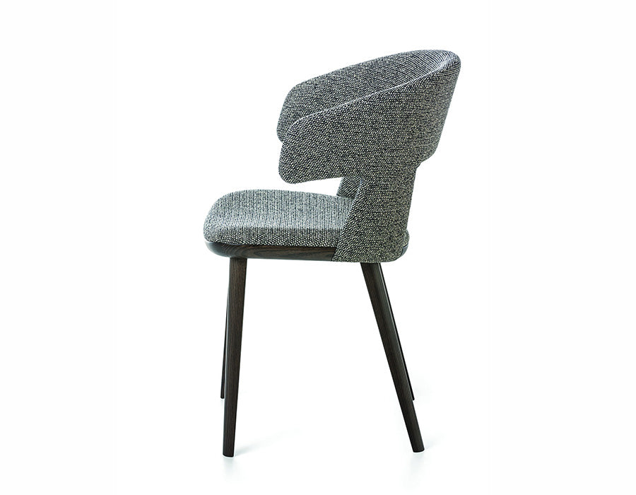 Path dining armchair in textured upholstery with open back and wraparound arms, shown in side view with dark wood legs.