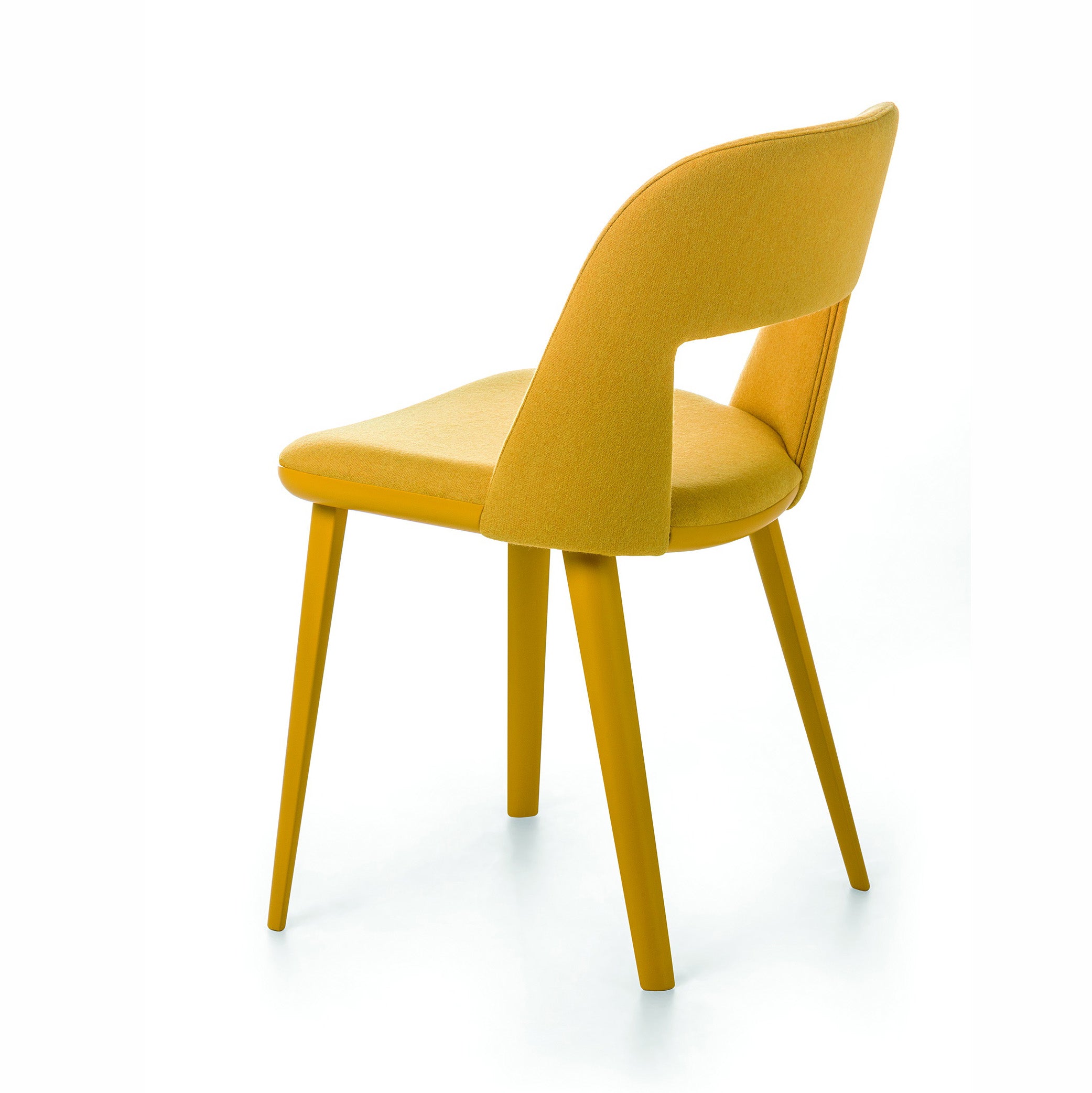 Path dining chair in yellow fabric with open back and curved shell, shown from rear three-quarter angle.