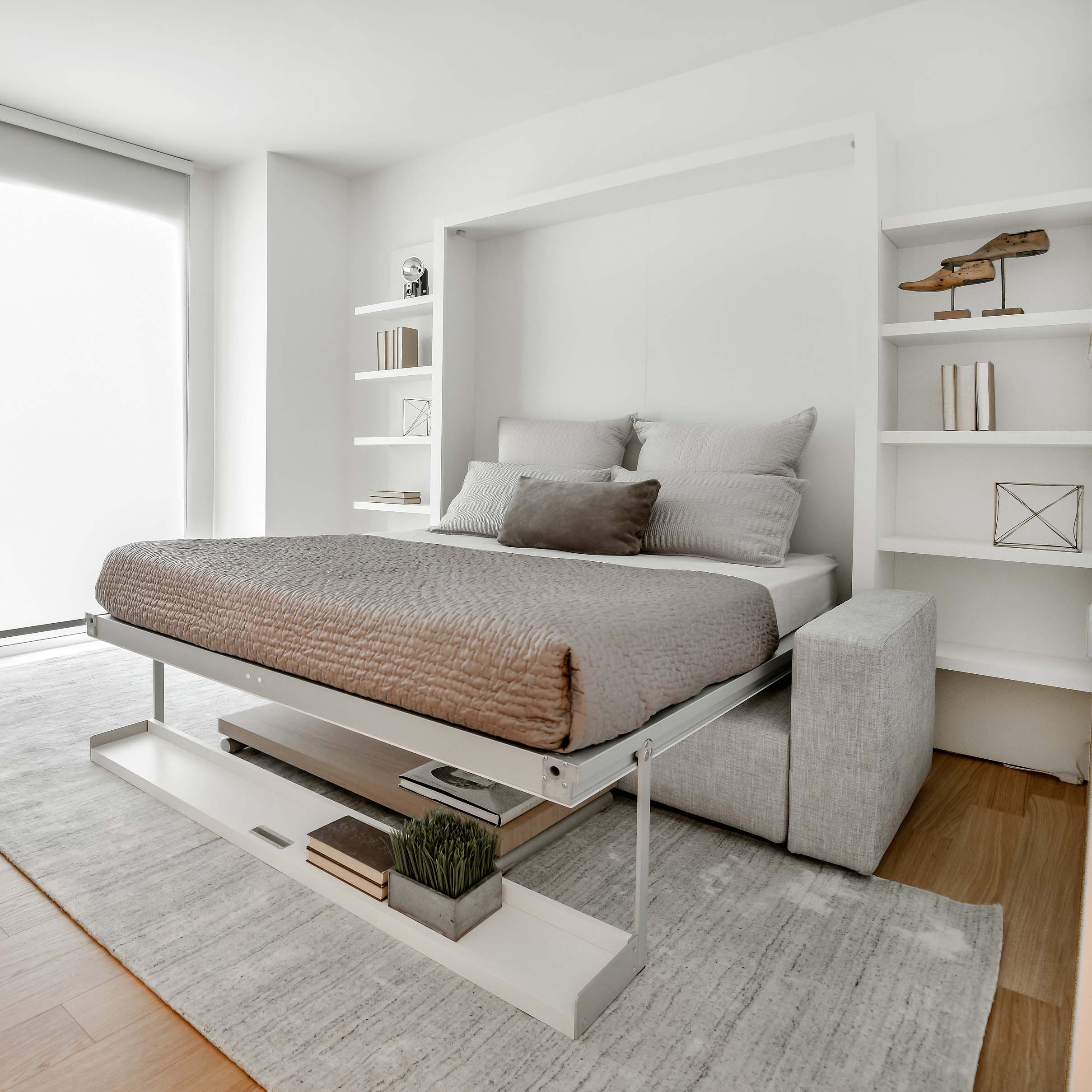 Angled view of Swing 0 wall bed in open position with upholstered sofa and custom side shelving.