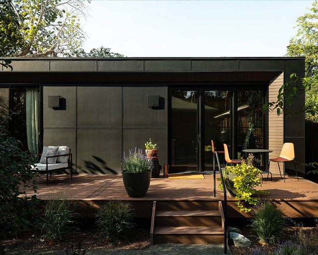 Modern prefab Modal ADU with outdoor deck, featuring sleek architecture, large glass doors, and inviting outdoor seating, ideal for luxury backyard living and guest accommodations.
