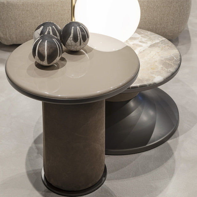 Set of three Bobbin side and coffee tables in varying heights and finishes, featuring sculptural bases and smooth tops in neutral tones.