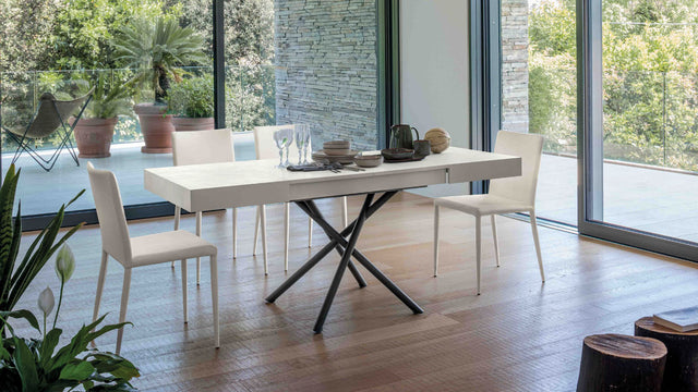 Brooklyn Mini table fully extended to its dining table form, styled for an intimate dinner with a natural outdoor view.