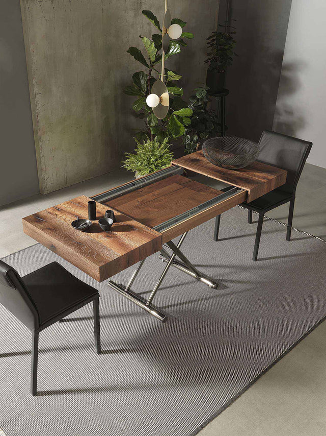 Cristallo Mini table in mid-transition, showcasing its hidden extension leaves being revealed, with a sleek wooden top and modern chrome legs, styled in a contemporary setting with minimalist decor.