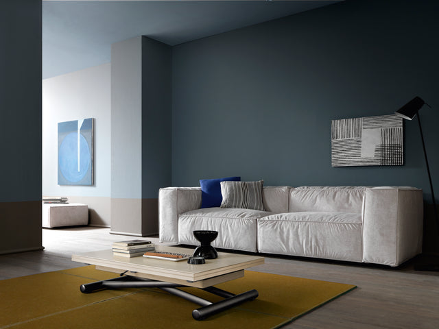 Doppio Mini coffee table in a modern living room with minimalist decor, shown in its lowered position.