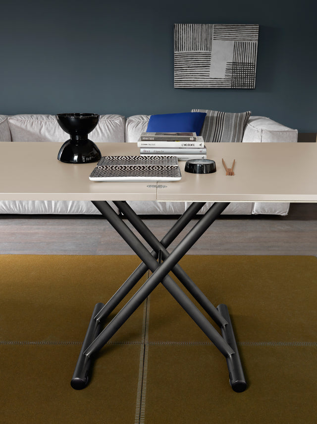 Side view of the Doppio Mini in its dining table position, showing height-adjustable crisscross base and elegant modern styling.