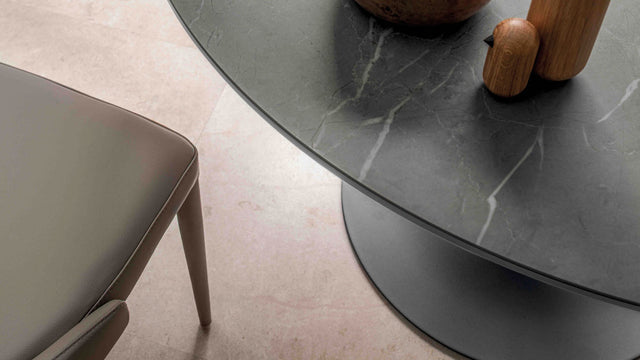 Close-up of the Luna Maxi table showcasing its sleek ceramic top with a marble-like finish and curved beveled edge.