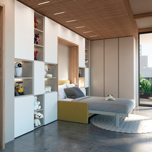 Children's room with a twin wall bed surrounded by white modular shelving, showcasing toys, books, and decor. The warm wood accents and a cozy yellow upholstered headboard add a playful yet sophisticated touch to the room.