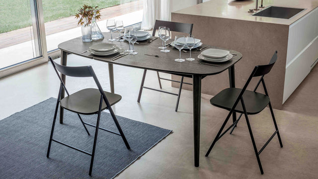 Surf table extended to full length of 67 inches, set as a dining table with elegant tableware and seating for four in a contemporary kitchen.