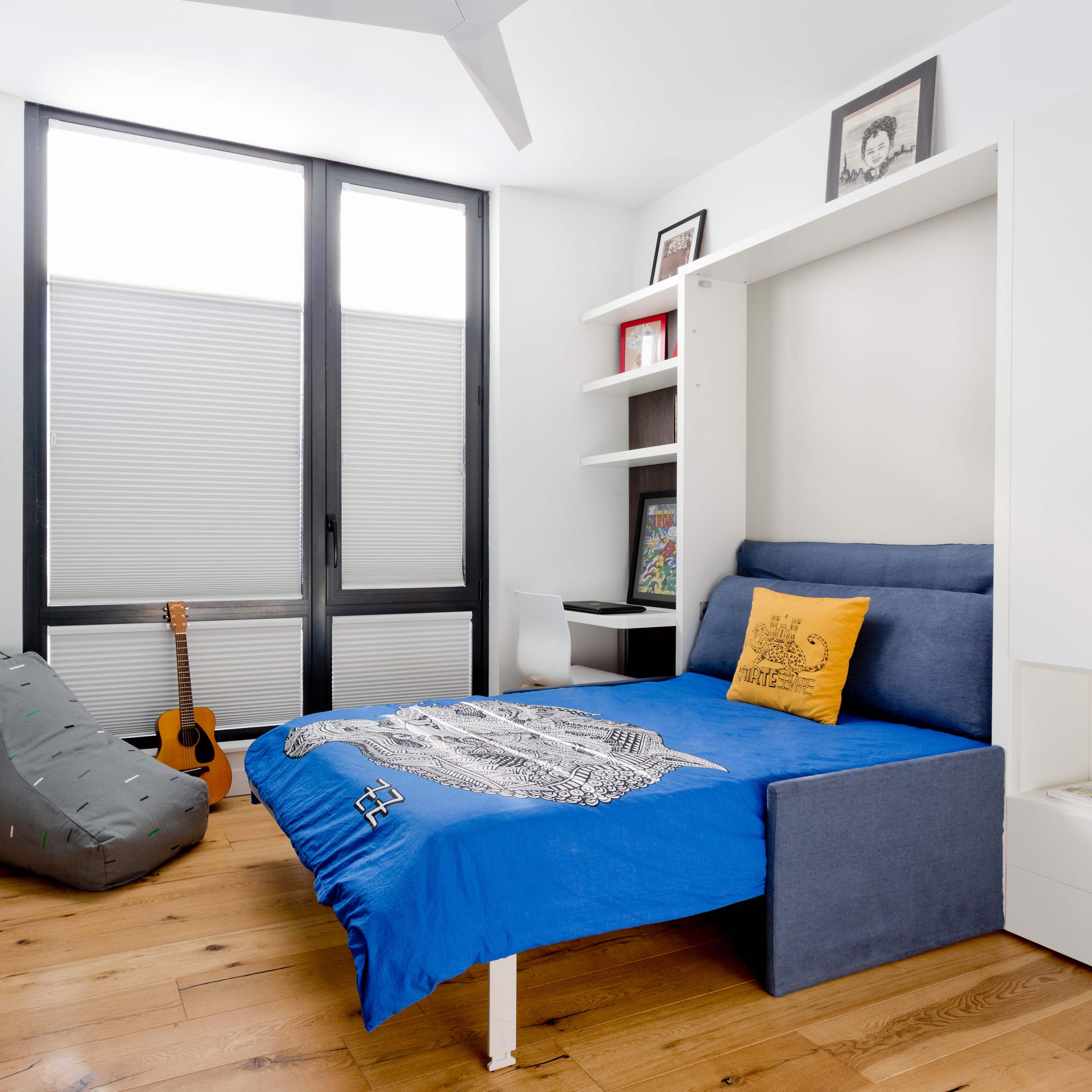 Altea Sofa Murphy Bed opened in a small NYC bedroom, featuring blue and yellow bedding – murphy bed with couch for space saving furniture needs