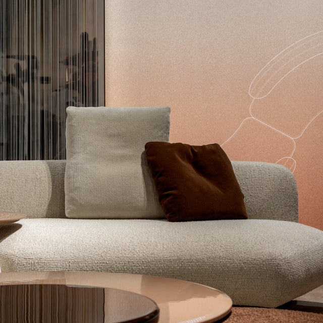 Kintai modern sectional sofa with cream upholstery and brown accent pillow.