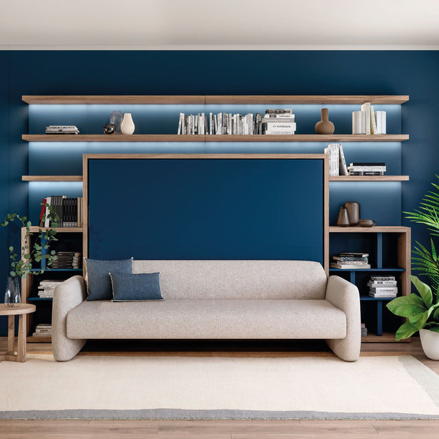 Resource Furniture Minerva horizontal Murphy bed with integrated beige sofa and walnut shelving, navy wall paneling and open shelves — multifunctional, space-saving furniture for small rooms.