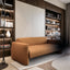 Resource Furniture Minerva vertical Murphy bed (closed) with integrated orange sofa, walnut shelving and warm built-in lighting — multifunctional, space-saving wall bed for small rooms.