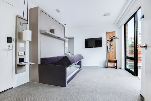 Resource Furniture Oslo Sofa wall bed (Murphy bed) — dark purple Oslo sofa-Murphy bed with integrated overhead shelf, built-in bedside panel with pendant light and fold-down shelf, hidden under-sofa storage compartment; multifunctional space-saving furniture and murphy bed with sofa for small apartments.