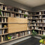 Maxi Bar closed with wood front panels, integrated into a custom library wall system with bookshelves and display storage.