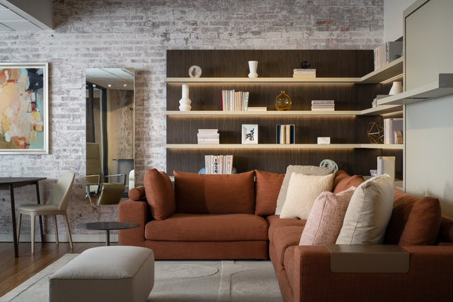 Tango sectional (rust) at Resource Furniture Seattle showroom — L-shaped sofa with plush cushions, wood shelves and brick wall. Photo: Anton Benedikt