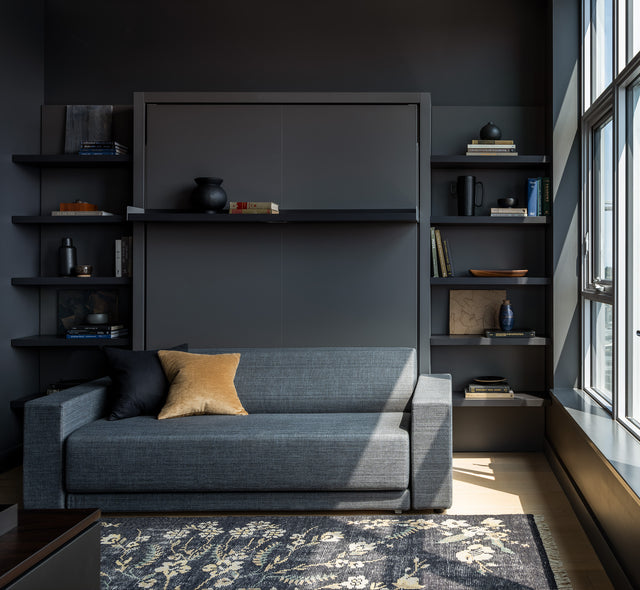 Oslo Murphy bed sofa closed in Seattle condo den designed by Michelle Dirkse, with custom shelving and Puget Sound–inspired tones.