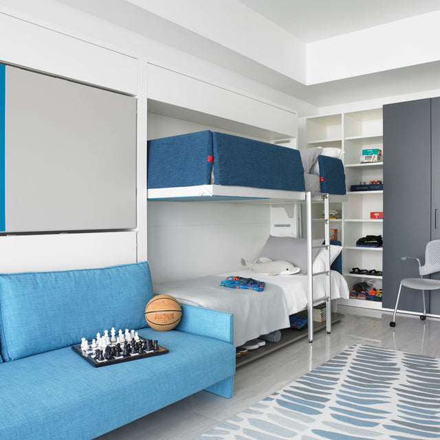 Transforming boys’ room by YZ Design Atrium at Armani Casa Miami with Resource Furniture wall bunk beds, blue sofa, and built-in storage for a multifunctional kids’ space.