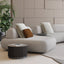 A modern living room with the Art Nova Curve sectional sofa in soft neutral upholstery, styled with sculptural cushions and low-profile tables.
