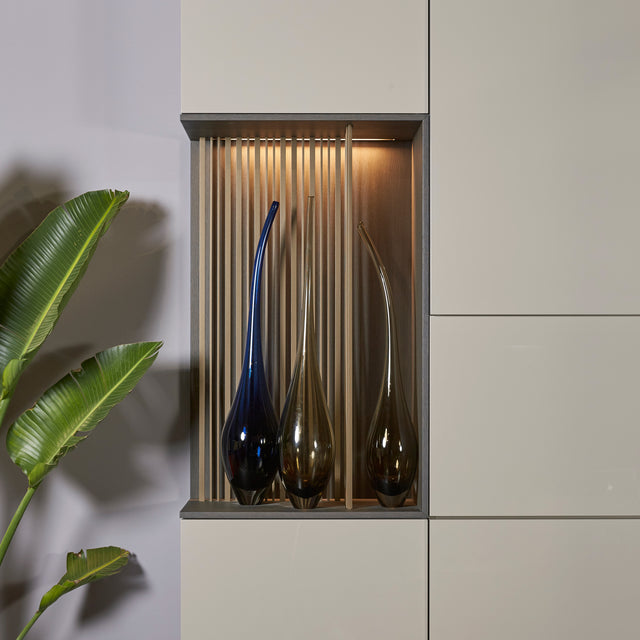 Custom cabinetry units with decorative wood panel shelving and glass vases — elegant built-in detail by Resource Furniture.
